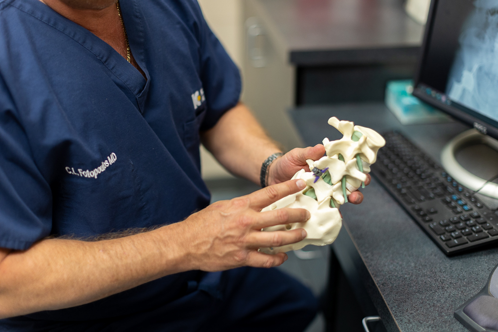 An orthopedic doctor kansas city holds a model