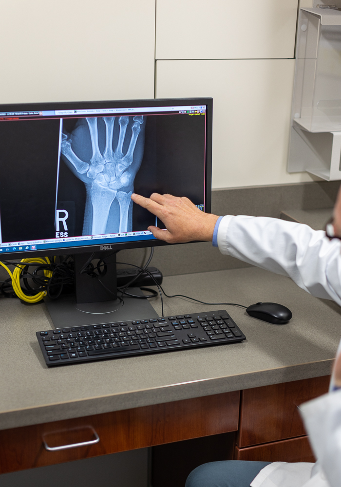 KCOA provider pointing to an X-ray of a hand.